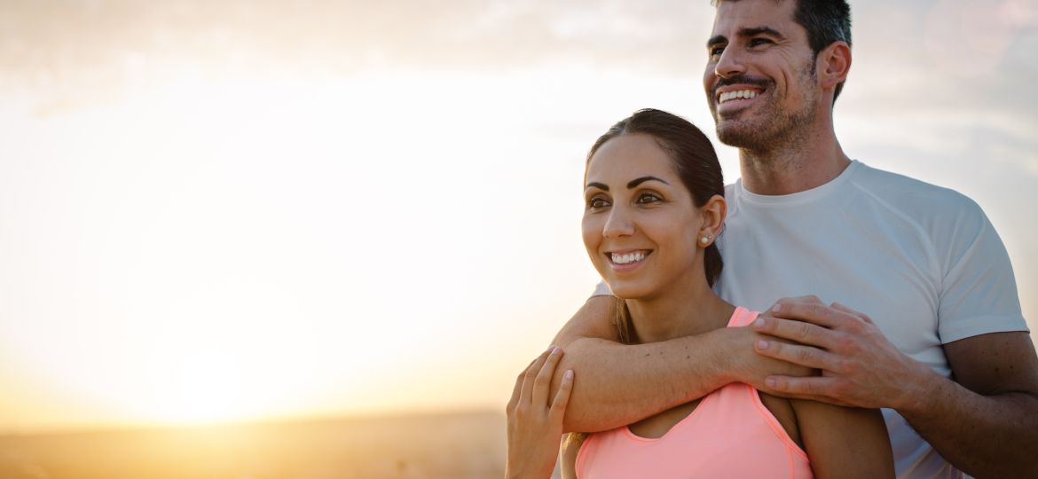 Happy sporty couple portrait at sunset