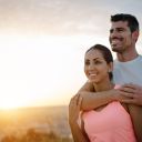 Couple healthy and fitness lifestyle. Happy sporty lovers portrait during outdoor training at sunset.